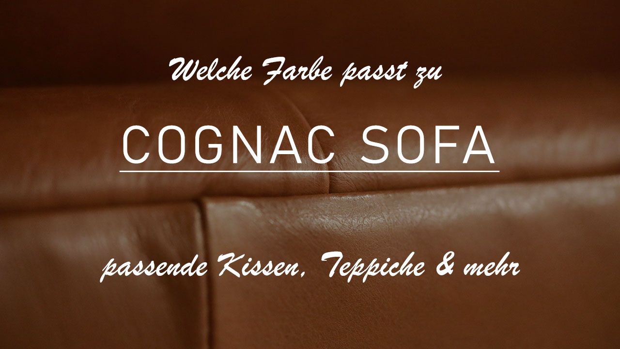 Titelbild des Beitrags "Welche Farbe passt zu cognac Sofa?" Zu sehen ist eine Nahaufnahme von einem cognacfarbenen Sofa. Das Bild ist leicht abgedunkelt, um die Überschrift, den Titel des Beitrags, sowie die Sub-Überschrift "passende Kissen, Teppiche und mehr" lesen zu können.